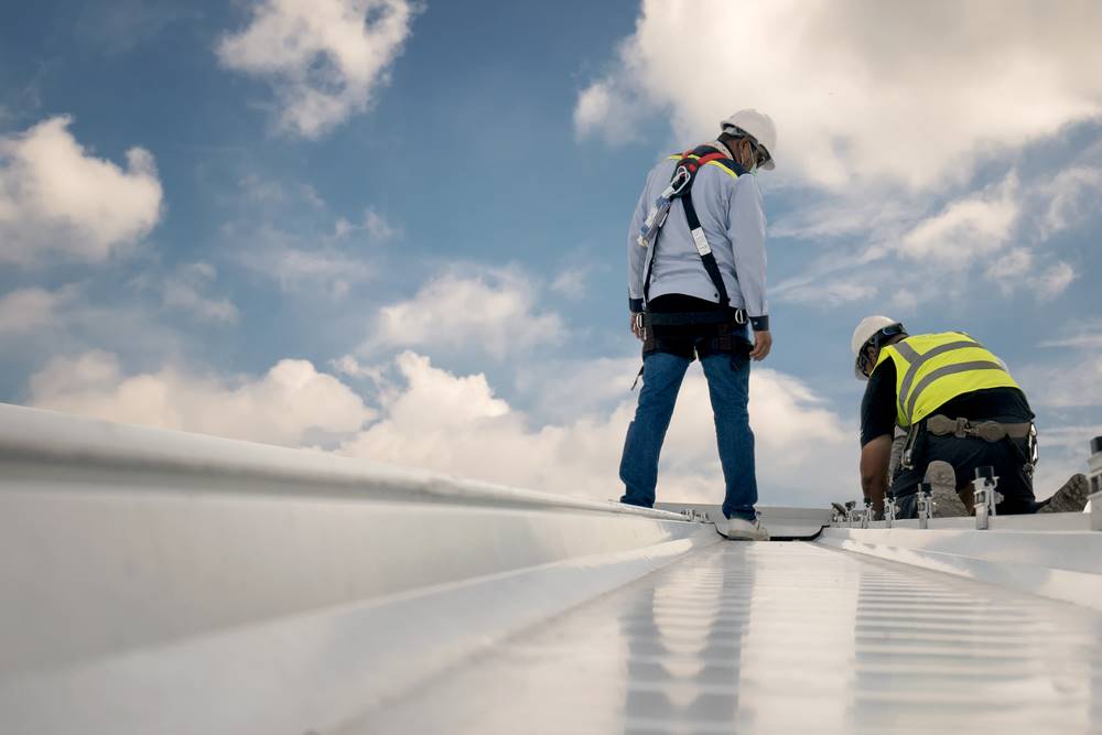 Construction workers on metal roof doing an inspection