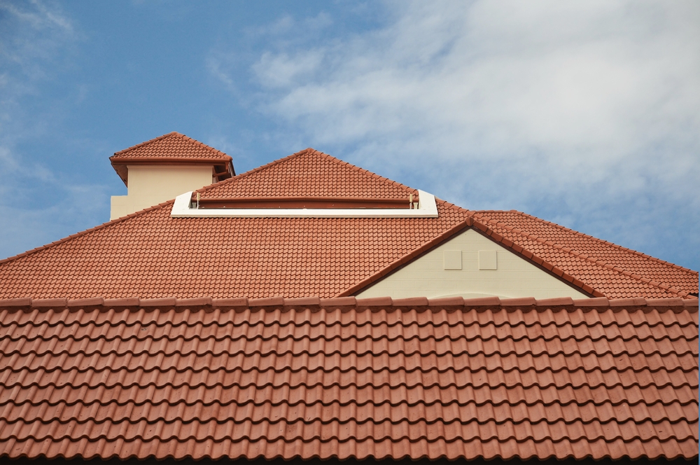 View of red roof tiles and cloudy sky on the background.