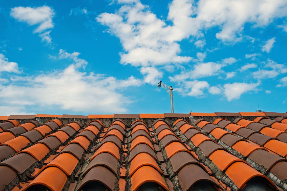 Roof with terracotta tile in miami, usa. Tile roofing on cloudy blue sky. Architecture and design. Rooftop with ceramic cover of classic clay material. Protection and shelter concept