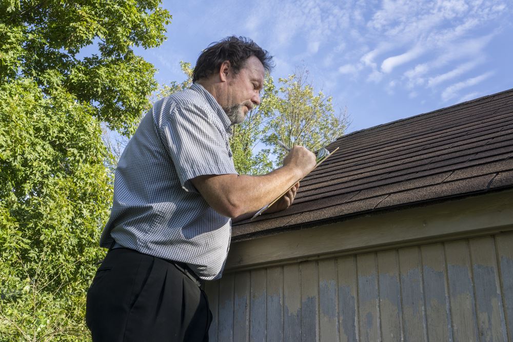 Man inspecting his roof before spring